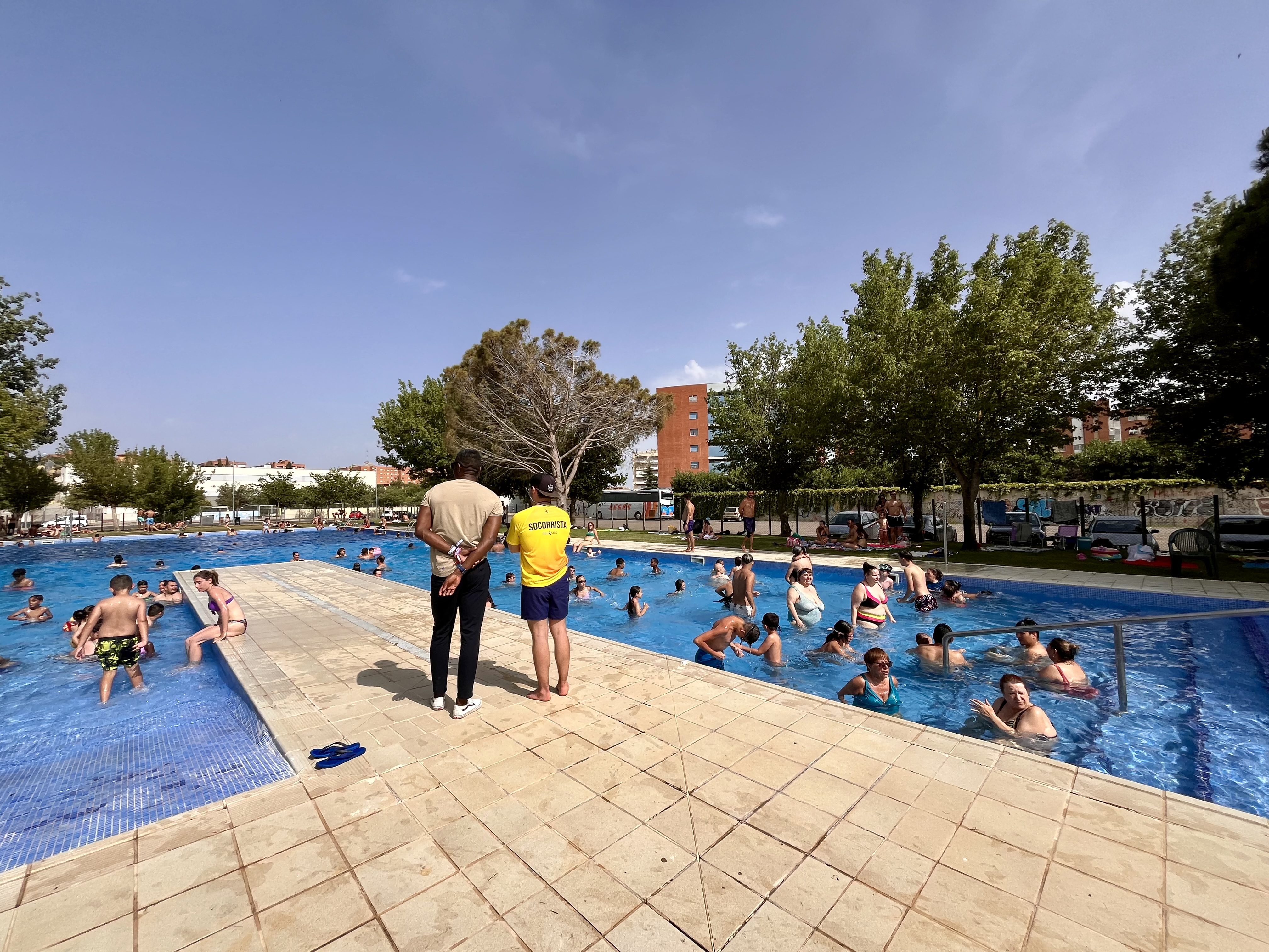 El regidor d'Esports, Jackson Quiñónez, amb un socorrista i banyistes a les piscines de Balàfia