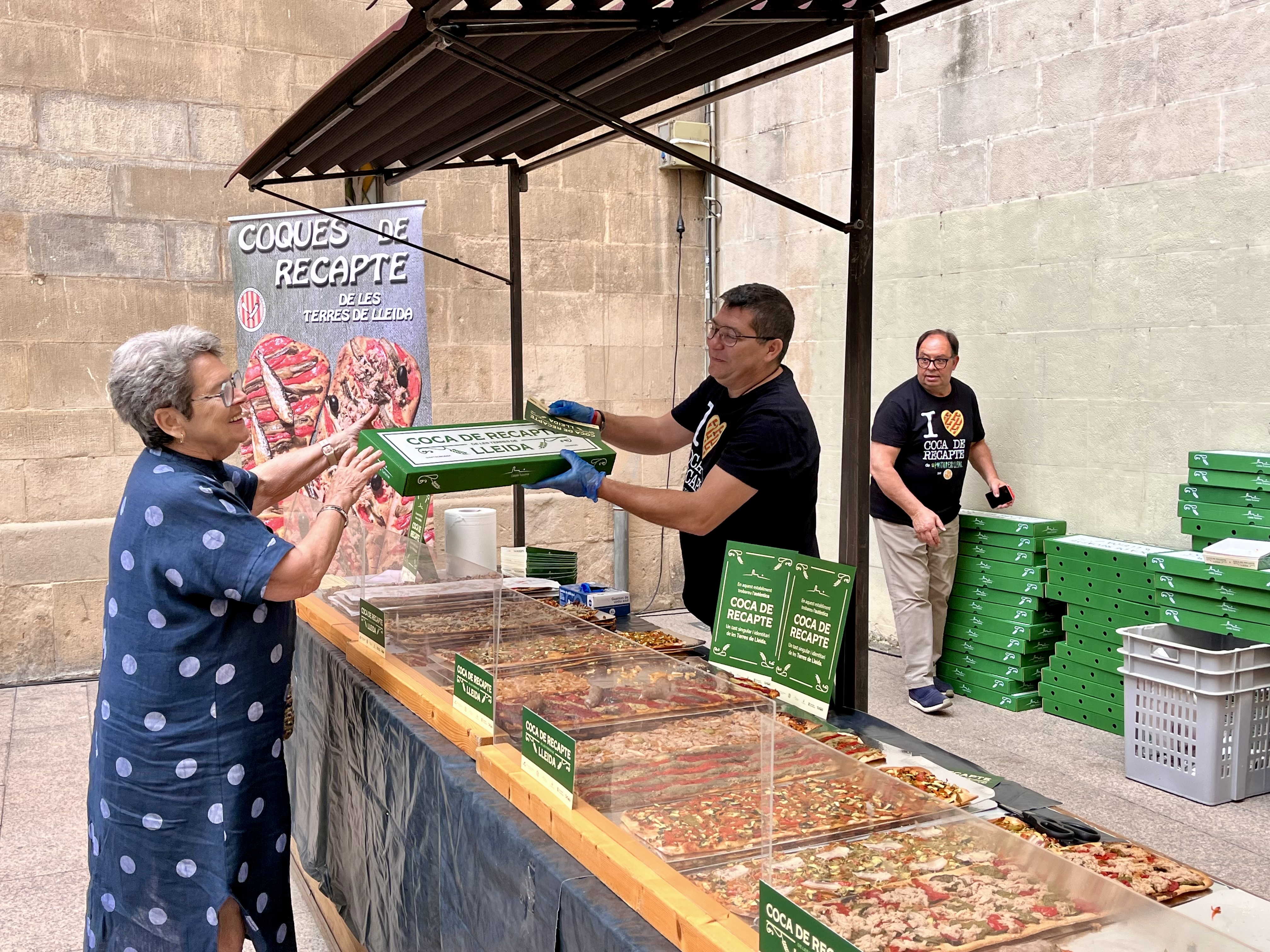 Una dona compra coca a l'estand instal·lat a la plaça de la Paeria pel Gremi de Forners de Lleida