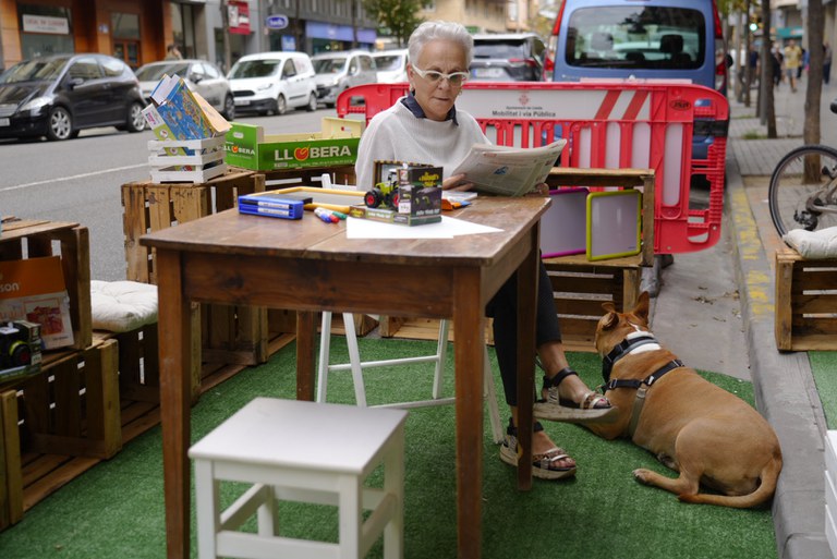 Una ciutadana i el seu gos, gaudint de l'espai habilitat per la botiga D19