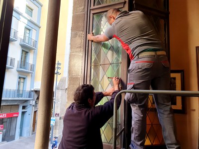 El moment de la instal·lació d'un dels vitralls que ha estat renovat, al despatx noble d'alcaldia.
