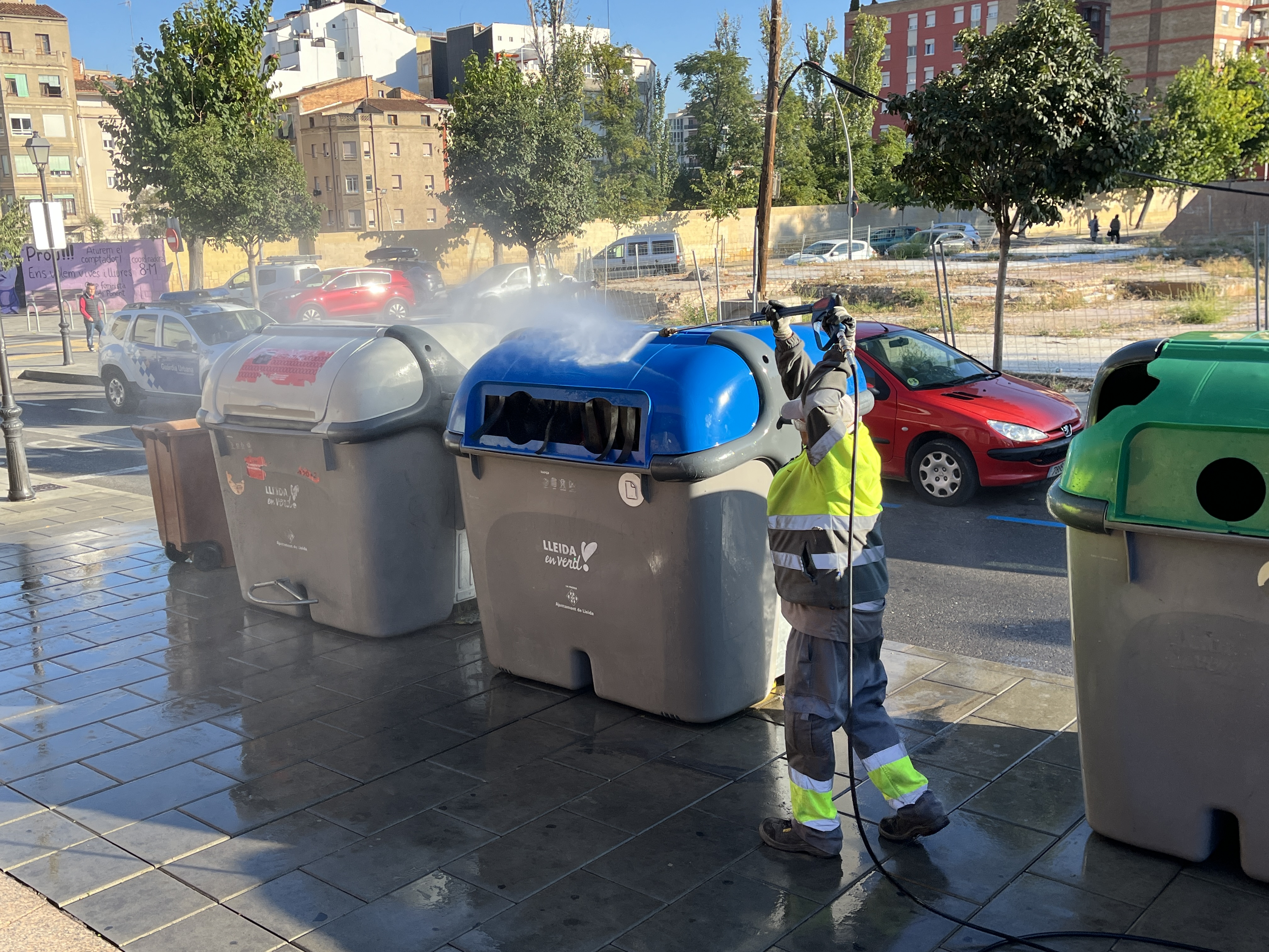 Neteja d'una illa de contenidors amb aigua a pressió