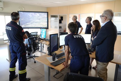L'alcalde i la regidora amb els comandamants, a la sala de control on es fa el seguiment i l'alerta de les emergències per incendis.