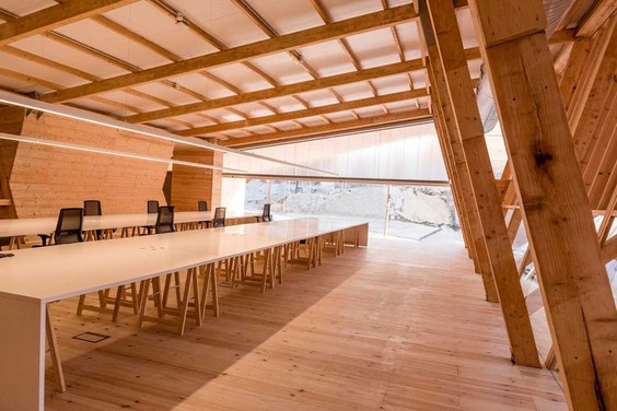 Espai amb dos taules llargues i cadires d'oficina