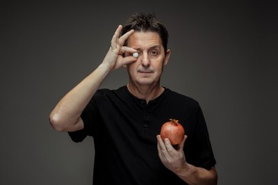 Imagen de Ramon Molins sujetando una canica blanca delante del ojo derecho y con la mano izquierda sujetando una granada.