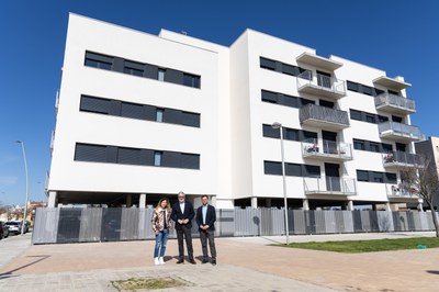El alcalde, Fèlix Larrosa, el concejal Roberto Pino y una representante de la promotora Soluciones Viviendas Magraners 88 frente a uno de los edificios de alquiler asequible de los Mangraners.